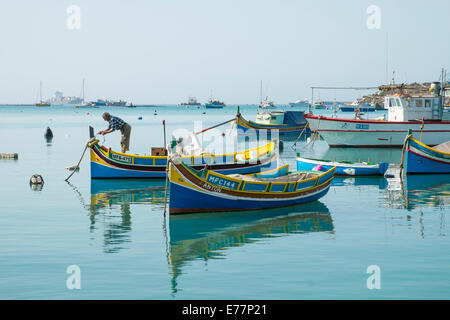 Fischer arbeitet an seinem Luzzu im Hafen von Marsaxlokk, Malta Stockfoto