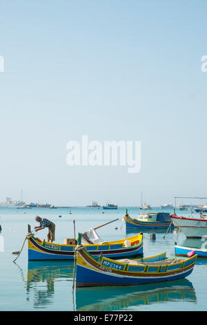 Fischer arbeitet an seinem Luzzu im Hafen von Marsaxlokk, Malta Stockfoto