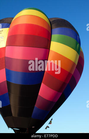 Regenbogenfarbenen Heißluftballon vor blauem Himmel Stockfoto