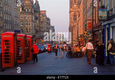 Telefonzellen, Fußgänger und Pubs entlang der Royal Mile in Edinburgh im Abendlicht Stockfoto