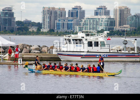 Toronto Police Dragon Boat Team geht mit dem Toronto Polizei Marine Boot Weg zum Start ihrer Rasse. Stockfoto