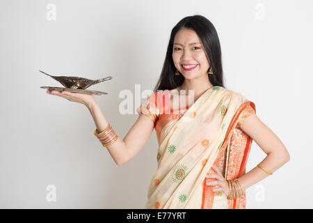 Indische Hausfrau Hand, die leeren Teller bereit für Lebensmittel stehen auf einfarbigen Hintergrund. Stockfoto