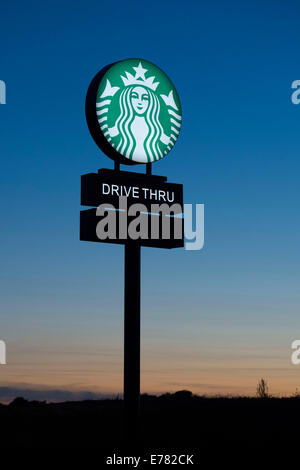 Starbucks Kaffee Fahrt durch Zeichen bei Sonnenuntergang. Stockfoto