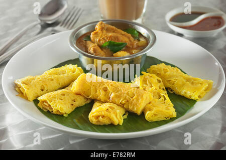 Roti Jala mit Kari Ayam. Lacy Pfannkuchen mit Hühnchen-Curry. Malaysia-Essen Stockfoto