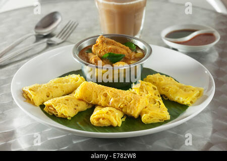 Roti Jala mit Kari Ayam. Lacy Pfannkuchen mit Hühnchen-Curry. Malaysia-Essen Stockfoto