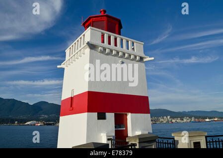 Brockton Point Leuchtturm an der Ufermauer im Stanley Park, Vancouver, Kanada.  Rot-weiße Leuchtturm am Burrard Inlet. Stockfoto