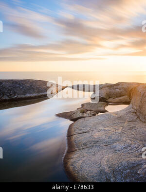 Glatte Flut Pool umgeben von Felsen bei Sonnenuntergang Stockfoto