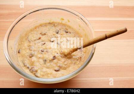 Bananen Brot in eine Glasschüssel mit einem hölzernen Löffel Teig vorbereitet Stockfoto