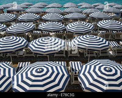 Blaue und weiße Sonnenschirme am Meer an der französischen Riviera Stockfoto