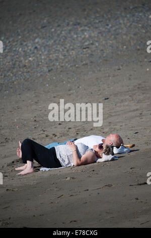 Aberystwyth, Wales, UK. 9. September 2014.  Da das Vereinigte Königreich in einer längeren warmen sonnigen Wetter sonnt, Sonnen Menschen liegen zum Sonnenbaden am Strand in Aberystwyth.   Temperaturen, die heute in dieser 'Indian Summer' bei 21ºc in London und Cardiff erreichte Bildnachweis: Keith Morris / Alamy Live News Stockfoto