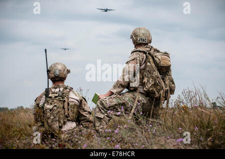 US Air Force Senior Airman Tyler Trocano, links, Anrufe in ein Abwurf von einer c-130 Hercules-Flugzeuge, 182. Airlift Wing, Illinois Air National Guard zugewiesen, wie techn. Sgt. Matthew Spittler während der Operation Northern Strike 2014 Aug. 11, 2014 unterstützt Stockfoto