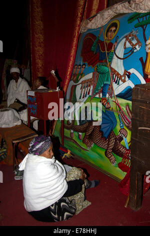 Frau in der Kirche betrachtet Bild des St George slaying der Drache Stockfoto