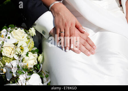 Trauringe auf Händen, neben den Brautstrauß Stockfoto