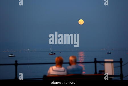 Swansea, Großbritannien. 9. September 2014.  Im Bild: ein paar auf einer Bank sitzend zu beobachten die Super Mond, bekannt als Perigäum über Swansea Bay aufgeht, wie gesehen von Mumbles, Süd-Wales, Vereinigtes Königreich. Bildnachweis: D Legakis/Alamy Live-Nachrichten Stockfoto