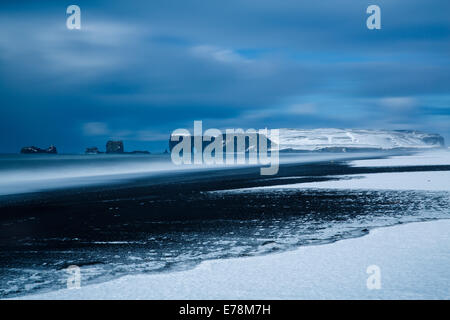 die Aussicht auf Reynisfjara schwarzen Sandstrand in der Nähe des Dorfes Vík Í Mýrdal in Richtung Dyrhólaey im Winter, Süden Islands Stockfoto