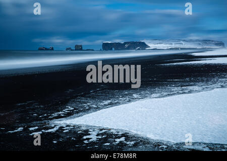 die Aussicht auf Reynisfjara schwarzen Sandstrand in der Nähe des Dorfes Vík Í Mýrdal in Richtung Dyrhólaey im Winter, Süden Islands Stockfoto