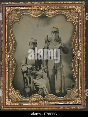 Dieses historische Bild zeigt zwei unidentifizierte Soldaten der Konföderierten in Uniform, bewaffnet mit Schwertern und Bajonettmusketen, die das militärische Leben während des Amerikanischen Bürgerkriegs symbolisieren. Stockfoto