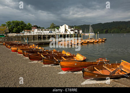 Reihe von bunten hölzerne Ruderboote am Ufer des Sees Windemere unter Gewitterhimmel in Cumbria, England Stockfoto