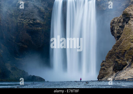 der einsame Figur von Wendy Stand am Fuße des Skógafoss, Süden Islands Stockfoto