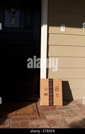 Amazon Lieferung verlassen vor einem Haus in Südkalifornien umwickelt mit Klebeband das Feuer Telefon Werbung Stockfoto