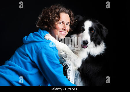 Junge Frau mit einem Border Collie, schwarz-weiß Stockfoto