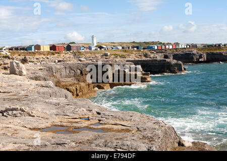 Alten weißen Leuchtturm jetzt eine Vogelbeobachtungsstation und Strandhütten an der Küste in Portland Bill, Isle of Portland, Dorset, England Stockfoto