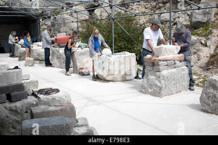 Bildhauer arbeiten an lokalen Portland (Naturstein) in ein Open-Air-Atelier Gemeinschaft an Tout Steinbruch, Isle of Portland, Dorset, England Stockfoto