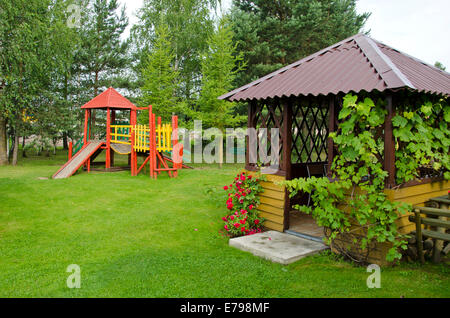 hölzerne Kinderspielplatz und Gartenhaus im Sommerpark Stockfoto