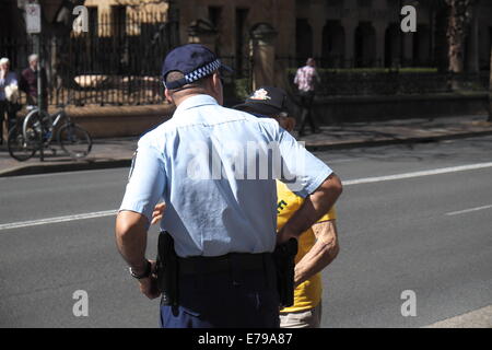 New-South.Wales Polizei-Offizier Unterstützung einen älteren Mann in der Macquarie Street, Sydney, Australien Stockfoto