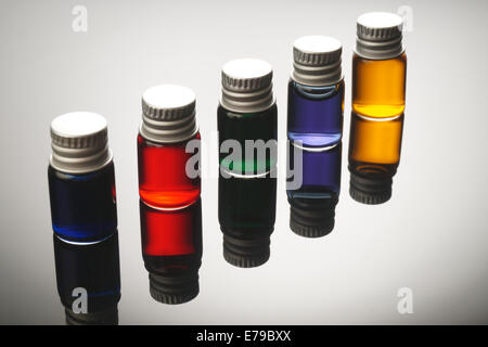 Fünf bunte Fläschchen isolierten auf schwarzen Hintergrund Stockfoto