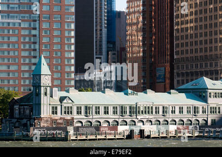 Riesigen Wolkenkratzern Uferpromenade vom Battery Park und Pier A. Pier A im Battery Park ist ein Gebäude, erbaut 1886 durch die Abteilung des Docks und Fähren, teilweise renoviert noch einen trauriger Zustand präsentiert, es scheint, dass es ein Streit zwischen den Behörden und die Unternehmen hinter seiner Rehabilitation. Im vergangenen Frühjahr begrüßt Amelia Earhart, die Königin und verschiedene Staatsoberhäupter. Stockfoto