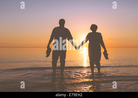 Gerne älteres paar Silhouetten am Strand Stockfoto