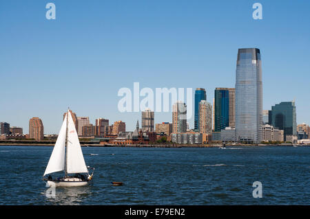 Battery Park City. Eine große Grünfläche mit einer Promenade entlang des Hudson River, beginnend an der Südspitze von Tribeca, in Rockefeller Park und erstreckt sich auf die Ferry Terminal auf Staten Island, teilte die Bühne mit modernen Gebäuden, die in dem Leben der Jet-Set-New York. Das Foto zeigt ein Segelschiff rund um die Bucht und einige Gebäude auf der Rückseite Jersey. Stockfoto