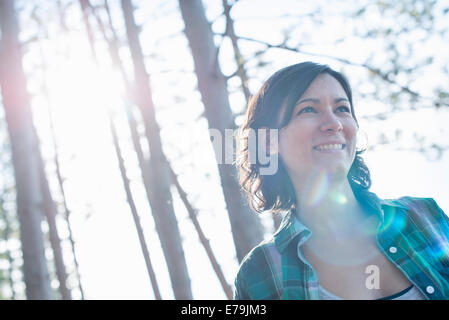 Eine Frau zu Fuß durch den Wald im Sommer. Stockfoto