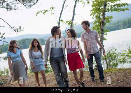 Eine Gruppe von Menschen, die genießen eines gemütlichen Spaziergang an einem See. Stockfoto