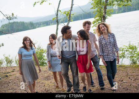 Eine Gruppe von Menschen, die genießen eines gemütlichen Spaziergang an einem See. Stockfoto