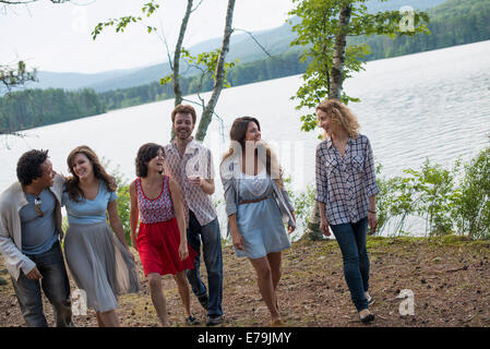 Eine Gruppe von Menschen, die genießen eines gemütlichen Spaziergang an einem See. Stockfoto