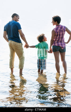 Familie, Mutter, Vater und Sohn spielen am Ufer eines Sees. Stockfoto