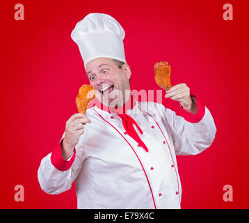 Koch in den Händen hält eine Hühnerkeule Stockfoto