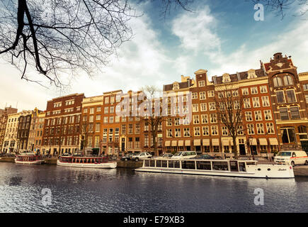 AMSTERDAM, Niederlande - 19. März 2014: Wohnhäuser entlang dem Kanal-Damm in sonnigen Frühlingstag Stockfoto