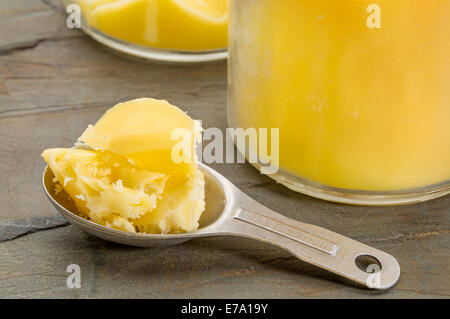 Glas Sand Messung Esslöffel Ghee - Butterschmalz auf Grunge Holz Stockfoto