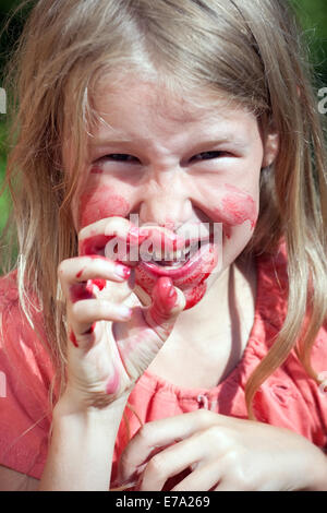 kleines Mädchen Portrait mit Mund rot von Saft als Vampir Stockfoto