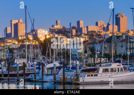 Boote im Hafen vor Marina District Häuser und Skyline von San Francisco in der Dämmerung angedockt Stockfoto