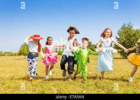 Kinder tragen Kostüme draußen im Feld ausführen Stockfoto