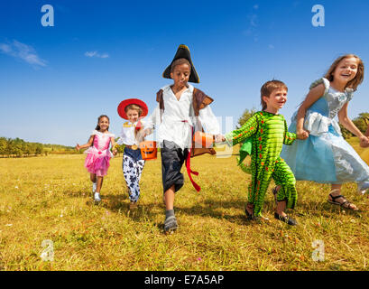 Gruppe von Kindern mit Kostümen im Park laufen Stockfoto