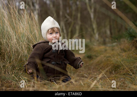 Babymädchen sitzen auf dem Rasen Stockfoto