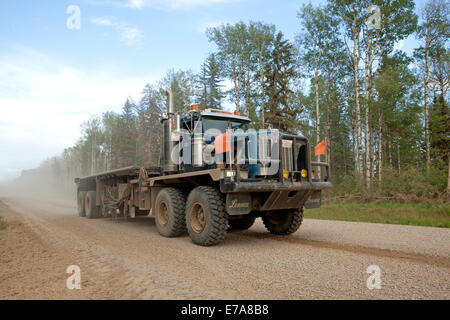 Spedition LKW auf staubigen geschotterten Straße durch Wald, Peace River, Alberta, Kanada Stockfoto