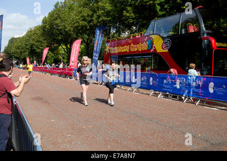 Läufer im Ziel gerade, Cardiff 10k Spaß laufen, Cathays Park, Cardiff, Wales, UK. Stockfoto