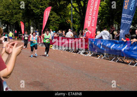 Läufer im Ziel gerade, Cardiff 10k Spaß laufen, Cathays Park, Cardiff, Wales, UK. Stockfoto