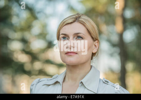 Nachdenkliche junge Frau, die im freien wegschauen Stockfoto